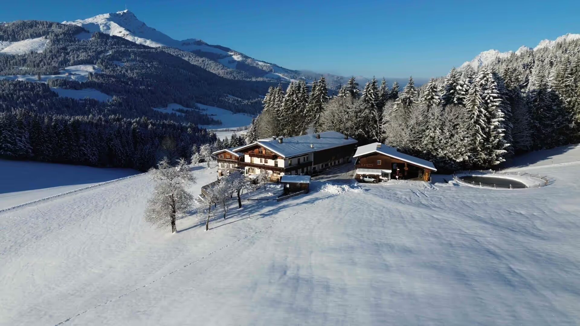 Vogelperspektive auf den Elsbichlhof im Winter, verschneite Landschaft