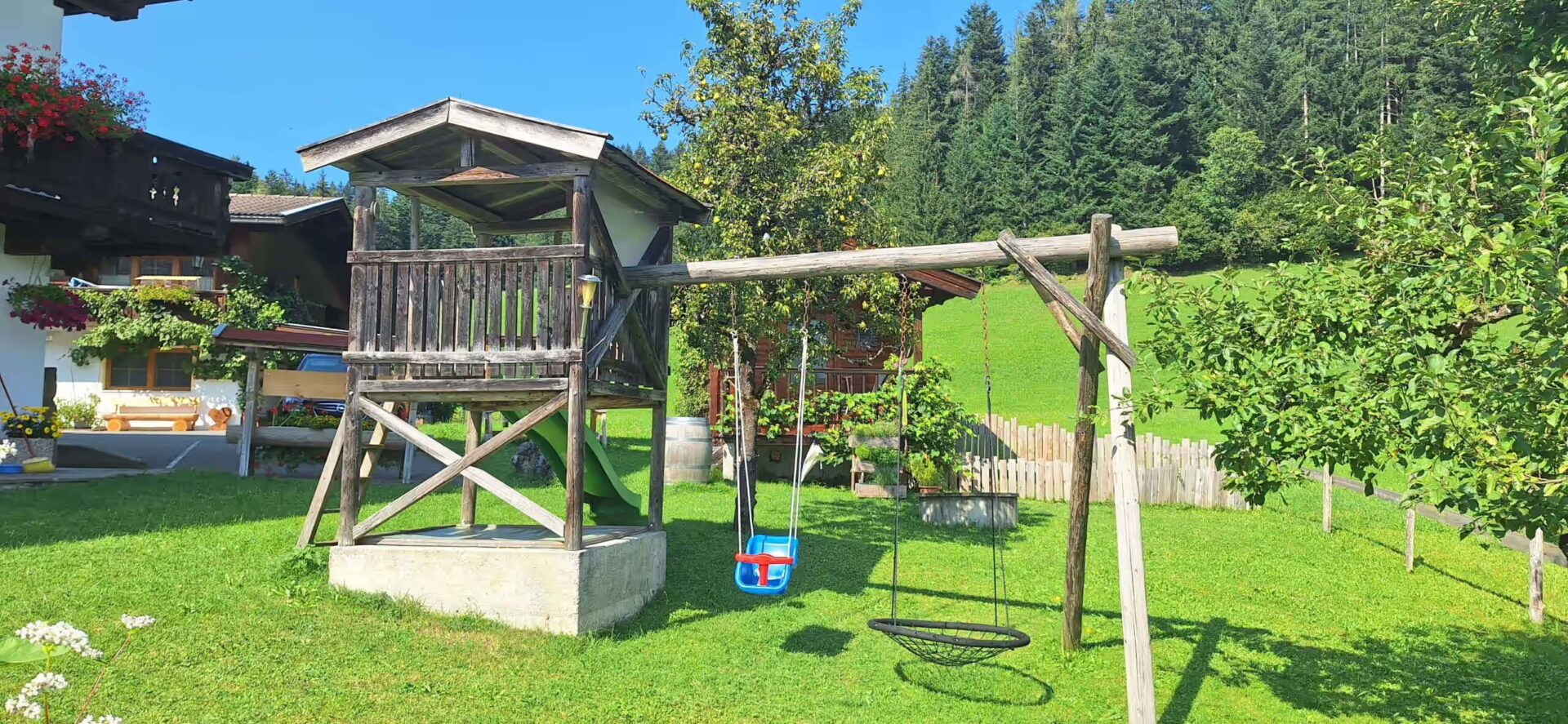 Spielhaus, nebenbei eine Kinderschaukel und eine für aeltere Kinder