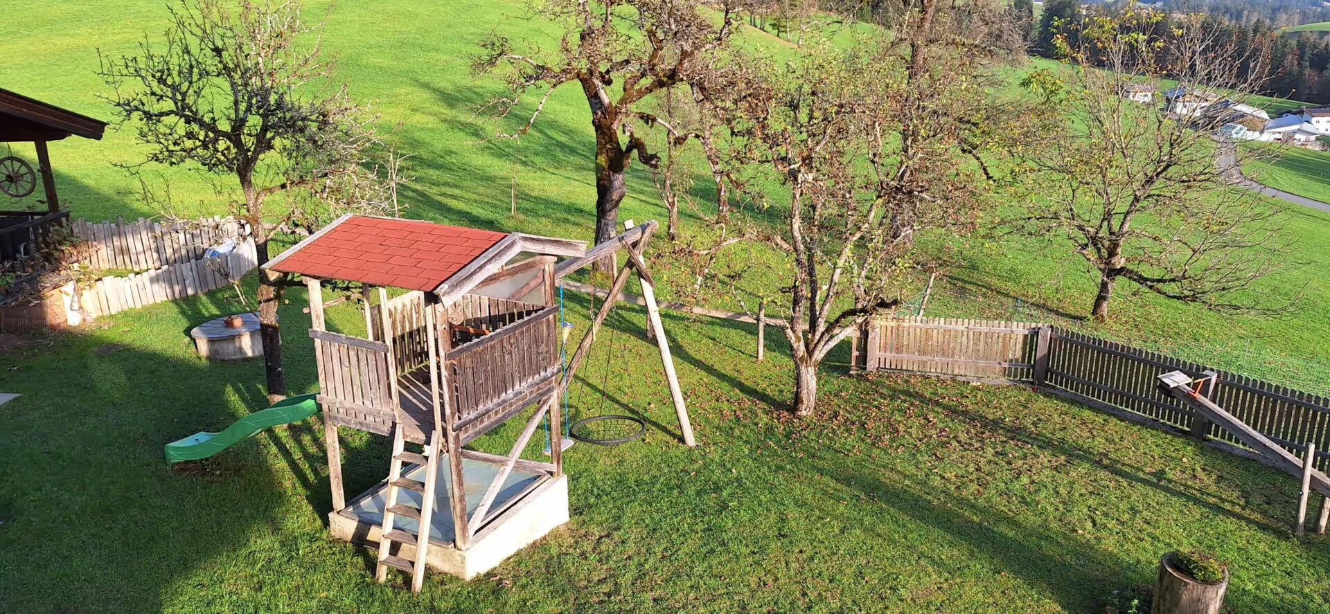 man sieht den Garten und das Spielhaus von der Vogelperspektive aus