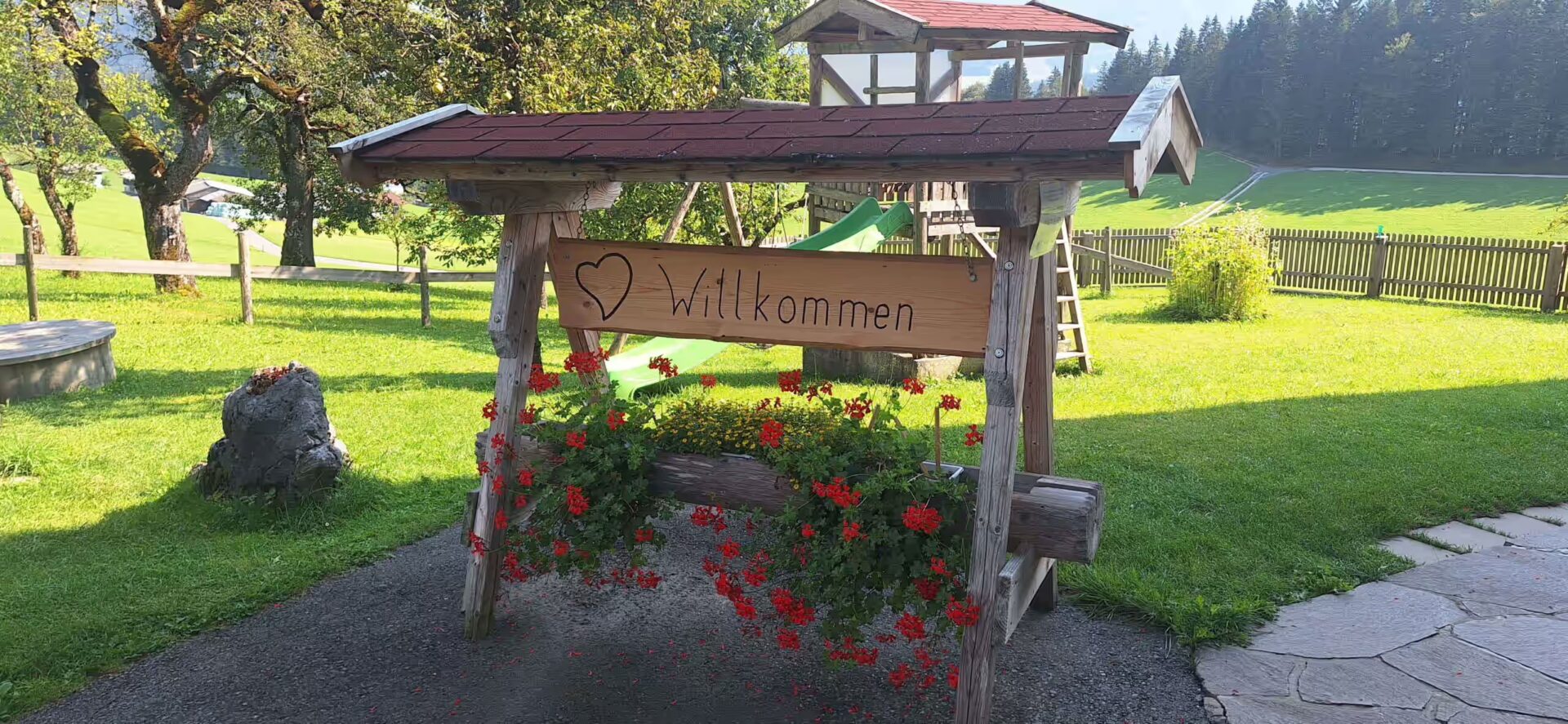 Blumen und ein Schild auf dem Willkommen steht, Begruessung am Hof