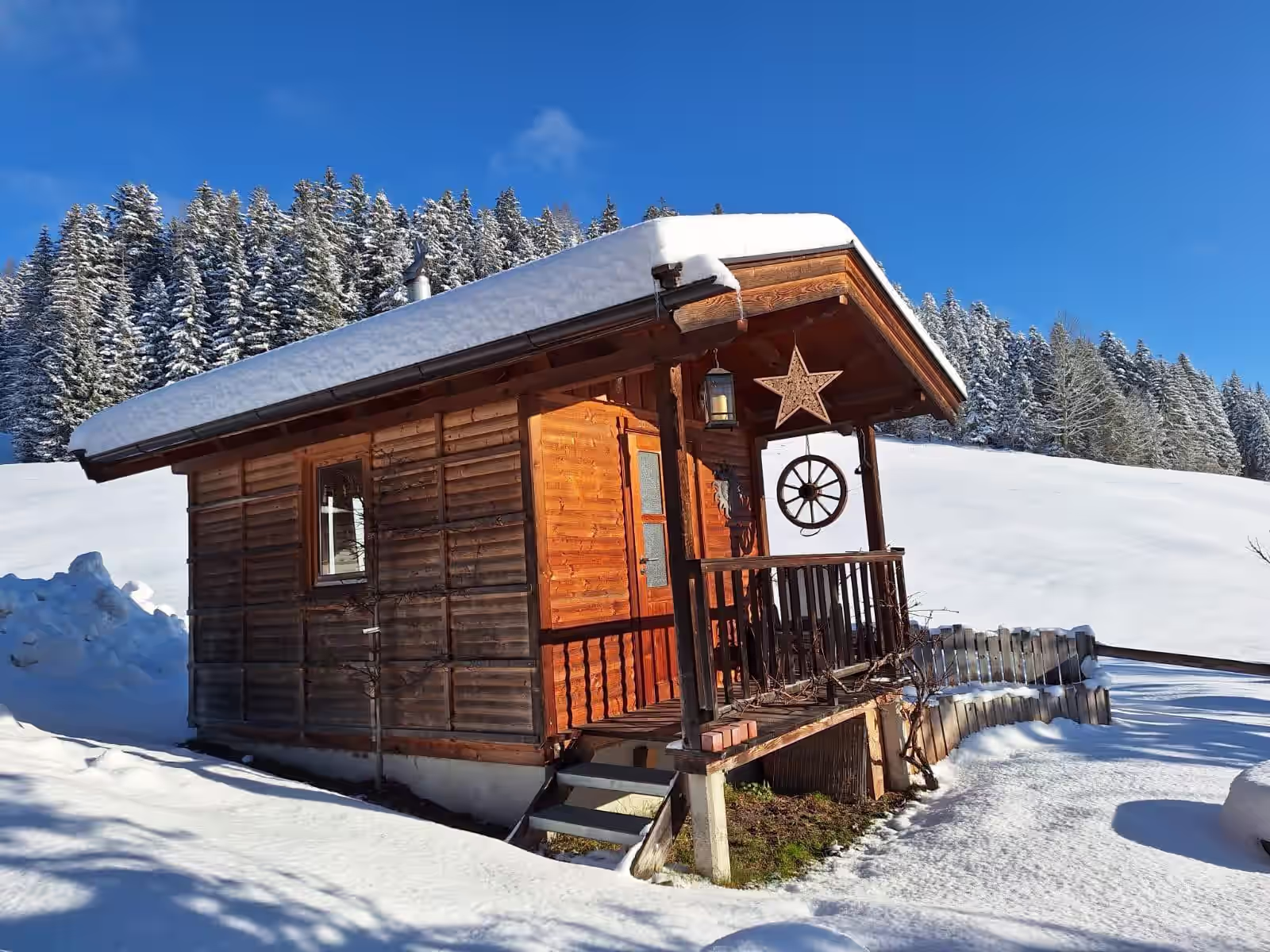 verschneite Landschaft im Hintergrund und Grillhuette im Vordergrund